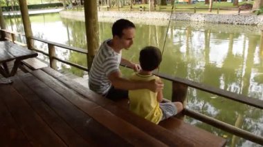 Babası (45 yaşında) ve oğlu (7 yaşında) Brezilyalılar bir yaz öğleden sonra birlikte balık tutuyorlar..
