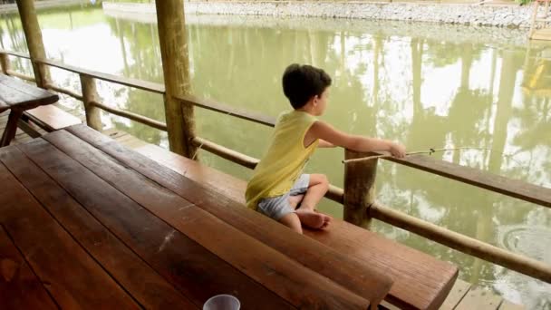 Criança brasileira de 7 anos pescando e mostrando o peixe para a câmera. — Vídeo de Stock