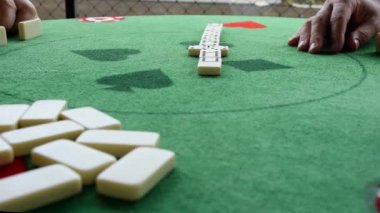 Domino oynayan iki olgun erkek (domino). Merkezi parçalar üzerine seçici odak (kenar görünüm).