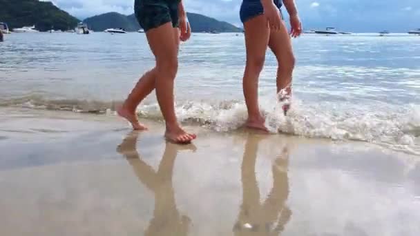 Duas crianças brasileiras (5 e 7 anos) caminhando na praia em um dia ensolarado. — Vídeo de Stock