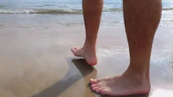 Einsamer Mann, der an einem sonnigen Nachmittag barfuß am Strand Sand läuft. — Stockvideo