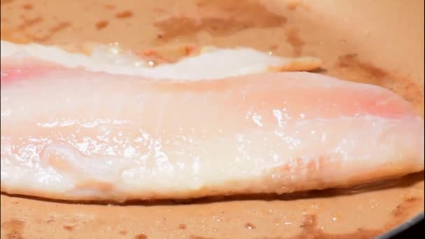 Close-up van de in boter gebakken tilapia-filet (Saint Peter) (zijspoor)). — Stockvideo