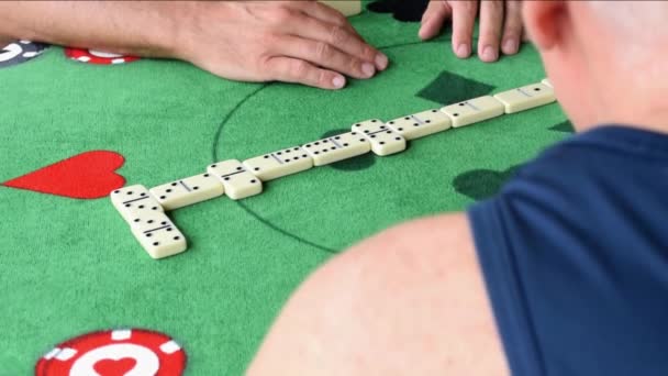 Dois homens maduros a jogar dominó. Ver ângulo sobre o ombro de um dos jogadores. — Vídeo de Stock