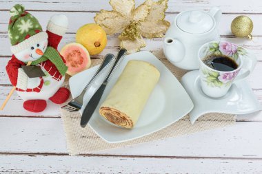 Bolo de rolo (rulo kek) bir Noel süslemesinin yanında. Geleneksel Brezilya tatlısıName.