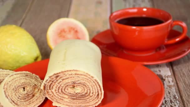 Bolo de rolo (rulo kek). Arka planda guava ve bir fincan kahve (panoramik). — Stok video