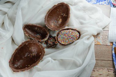 Birbirinin içinde paskalya yumurtalarının yarısı. Renkli çikolata parçacıklarıyla kaplı (Pinata Paskalya yumurtası)).