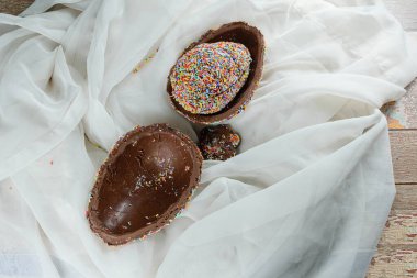 Renkli çikolata parçacıklarıyla kaplanmış başka bir yumurta ile doldurulmuş Paskalya yumurtası (Pinata Paskalya yumurtası)).