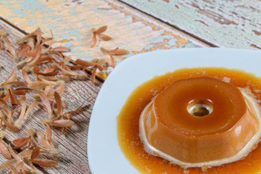 Karamel şuruplu dulce de leche pudinginin yanı sıra uçan tohumlar (Triplaris americana). Geleneksel Brezilya tatlısı..
