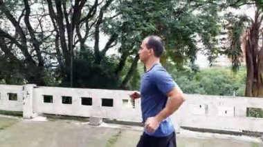 45 yaşında Brezilyalı bir adam bir yaz öğleden sonra dışarı koşuyor. Yan görünüm.