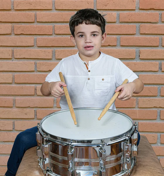 Sedmileté Dítě Zíralo Kamery Hrálo Bubny Cihlová Zeď Pozadí — Stock fotografie
