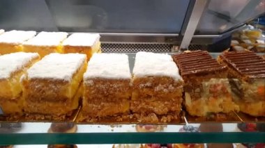 Şekerli kremayla doldurulmuş sütle dilimler halinde pasta. Aşağıda, böğürtlenli, kremalı ve çikolatalı tatlılar var..