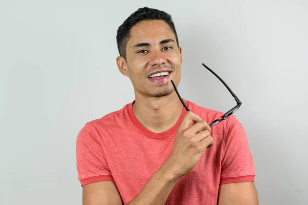 Gülümseyen Brezilyalı 28 yaşında, kameraya bakıyor ve güneş gözlüğü tutuyor..