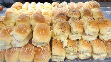 Jambon ve mozzarella peynirli mini ekmekler. Üstünde kekik otu ve granüllü parmesan peyniri var..