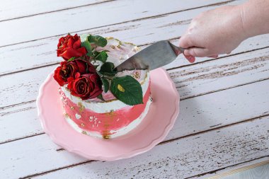 Üstünde İsviçre kreması olan bir dilim çikolatalı pasta kesiyorum..