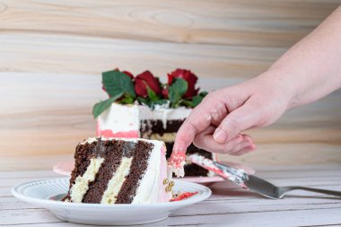 Şekerci parmağıyla pasta diliminden kremayı çıkarıyor. Maskaralı çikolatalı pasta..