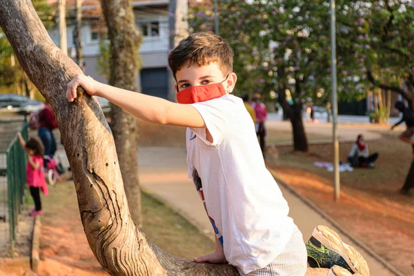 Niño Años Con Máscara Tronco Árbol Una Plaza Pública —  Fotos de Stock