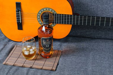 Sao Paulo / Sao Paulo / Brasil - Ağustos 01: 20: Arka planda gitar olan kahverengi bir paspas üzerinde viski.