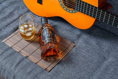Sao Paulo / Sao Paulo / Brasil - 1 Ağustos 2020 tarihinde: Kanepede cam, viski ve gitar şişesi.