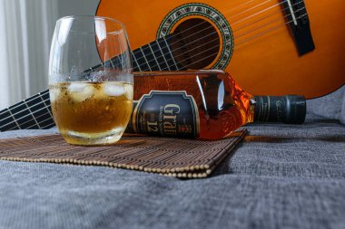 Sao Paulo / Sao Paulo / Brasil - Ağustos 01: 20: Arka planda gitar eşliğinde uzanan viski şişesi.