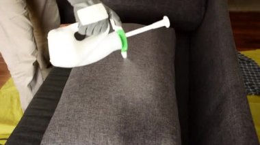 Kanepe yastığına temizleyici sprey sıkmak..
