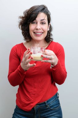 Spontane fotoğraf. Gülümseyen Brezilyalı kadın elinde kapuçino bardağıyla komik bir hikaye anlatıyor..