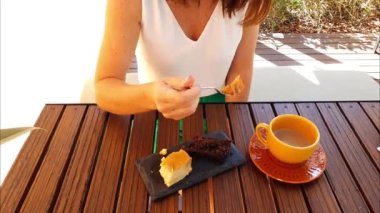 Bir parça muzlu keki çatallayan bir kadın, kayrak taşında servis edilmiş. Ve kahveyle süt içmek..