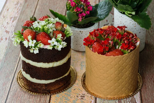질감있는 보드로 케이크 옆에는 초콜릿 케이크가 딸기와 꽃으로 장식되어 — 스톡 사진