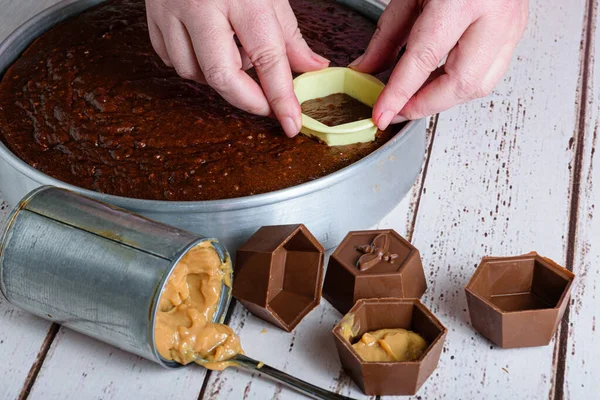 Şekerci bir parça Brezilya ballı keki dilimliyor. Dulce de leche ile doldurulmuş çikolata kalıbına yerleştirmek için..