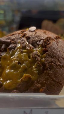 Pastane görevlisi vitrinden çikolatalı kurabiye ve krema alıyor..