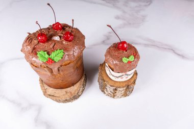 Erimiş çikolata kaplamalı ve ağaç gövdesinde kirazlı Panettone..