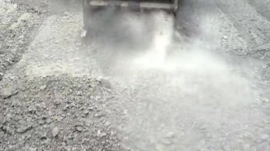 Makine eski asfaltı kaldırıyor ve orijinal ses ile bir sürü toz yaratıyor.