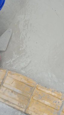 Sao Paulo şehrinde çimentoyla kaldırımı tamir eden bir tuğla ustası _ üst görünüm _ dikey.