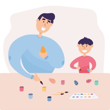 Mutlu Aile Paskalya Bahar Tatili Kutlaması için Hazırlanıyor. Tavşan kulaklı baba ve oğul yumurta boyuyor.. 