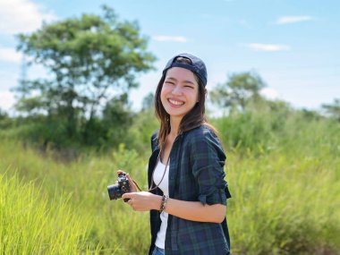 Kameralarıyla seyahat eden Asyalı kadınlar aydınlık bir günde kameraya gülümsediler..