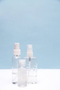 Beyaz ve mavi arka planda fotokopi alanı olan antiseptik şişeler. El dezenfektanı. Sağlık hizmeti kavramı