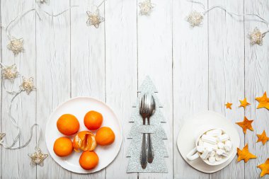 Mandalinalı Noel kompozisyonu, çelenkler ve beyaz tahta üzerinde marşmelov olan bir fincan. Yeni Yıl ya da Noel arkaplanı metin için kullanılacak.