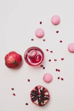 Minimalist natürmort meyve ve bardakta nar suyu olan hafif arka planda seçici bir odak noktasında kalp şeklinde bir buz küpü bulunan minimalist bir hayat.