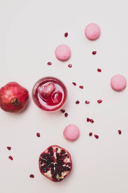 Minimalist natürmort meyve ve bardakta nar suyu olan hafif arka planda seçici bir odak noktasında kalp şeklinde bir buz küpü bulunan minimalist bir hayat.