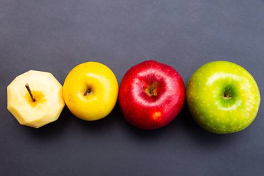 Elmalar yeşil, sarı, kırmızı ve elma kabuksuz siyah arka plan. Fotokopi alanı olan sağlıklı gıda kavramı