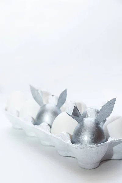Яйца Кроличьими Ушами Раскрашены Серебром Белыми Яйцами Коробке Белом Фоне — стоковое фото