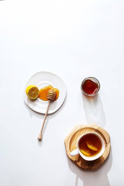Hafif arka planda bal ve limonlu bitki çayı, sağlıklı gıda konsepti. Kopyalama alanı olan minimalist düz.