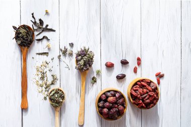 Varios bitki çayı. Papatya çayı, papatya çayı, gül kalçası, Origanum, Goji üzümü ve çaydanlık tatlısı beyaz ahşap masa üzerinde fotokopi alanı. Doğal bitkisel ilaçlar.