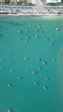 Denizdeki yerel balıkçı tekneleri. Açık bir günde güzel bir turkuaz su. Çeşitli teknelerle kuş bakışı okyanus manzarası.