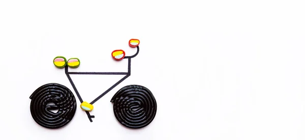 酒とお菓子で作られた自転車のミニマルなイメージ 白い背景の自転車 — ストック写真