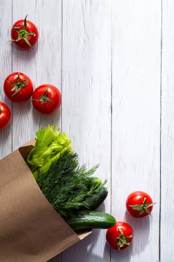 Kese kağıdında taze, organik sebzeler. Sağlıklı beslenme ve sürdürülebilir yaşam tarzı dışında. Kopya alanı olan beyaz ahşap bir masada minimalist bir hayat..