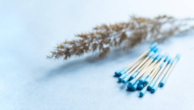 Mavi arka planda bambu pamuklu çubukların çevre dostu kompozisyonu, kopyalama alanı. Sürdürülebilir yaşam tarzı kavramı, sıfır atık, plastiksiz.