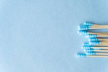 Mavi arka planda bambu pamuklu çubukların çevre dostu kompozisyonu, kopyalama alanı. Sürdürülebilir yaşam tarzı kavramı, sıfır atık, plastiksiz.