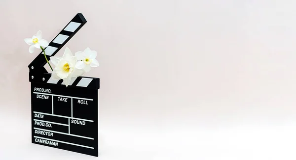 春の花と映画からクラップボード ビデオ映画や水仙の花を作るためのクラッパーボードの最小限の静物画 — ストック写真