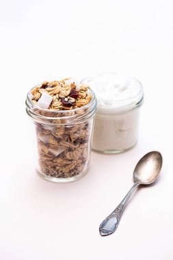 Sağlıklı kahvaltı konsepti. Kızılcıklı granola, hindistan cevizi, chia tohumu ve Yunan yoğurdu. Kopyalama alanı olan minimalist natürmort yaşam.