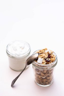 Sağlıklı kahvaltı konsepti. Kızılcıklı granola, hindistan cevizi, chia tohumu ve Yunan yoğurdu. Kopyalama alanı olan minimalist natürmort yaşam.